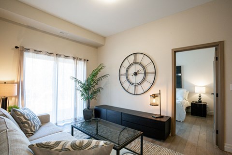 a living room with a couch and a clock on the wall